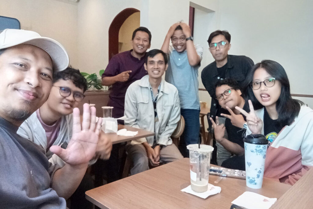 Group of friends posing and smiling at a café table